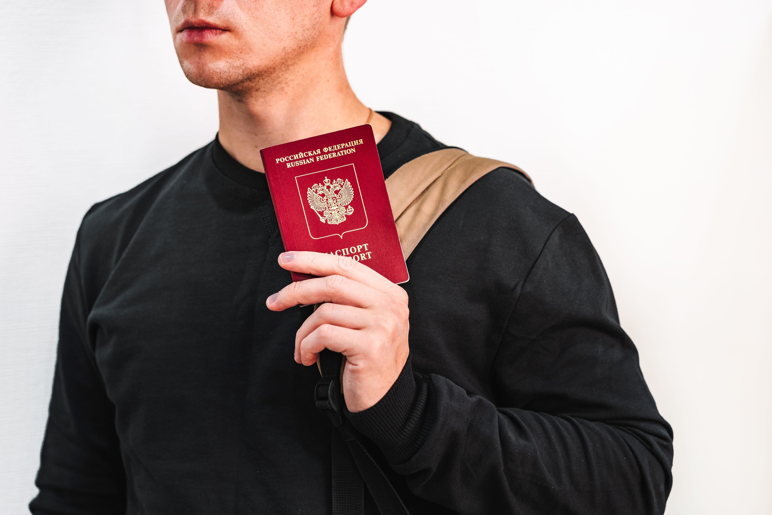 A man holding up a Russian passport