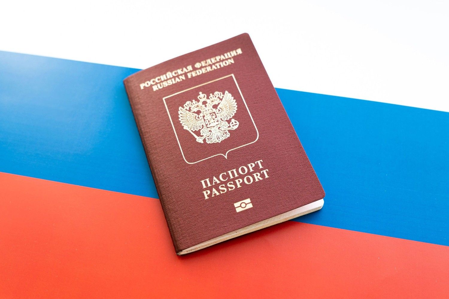 A Russian Passport On Top Of A Russian Flag