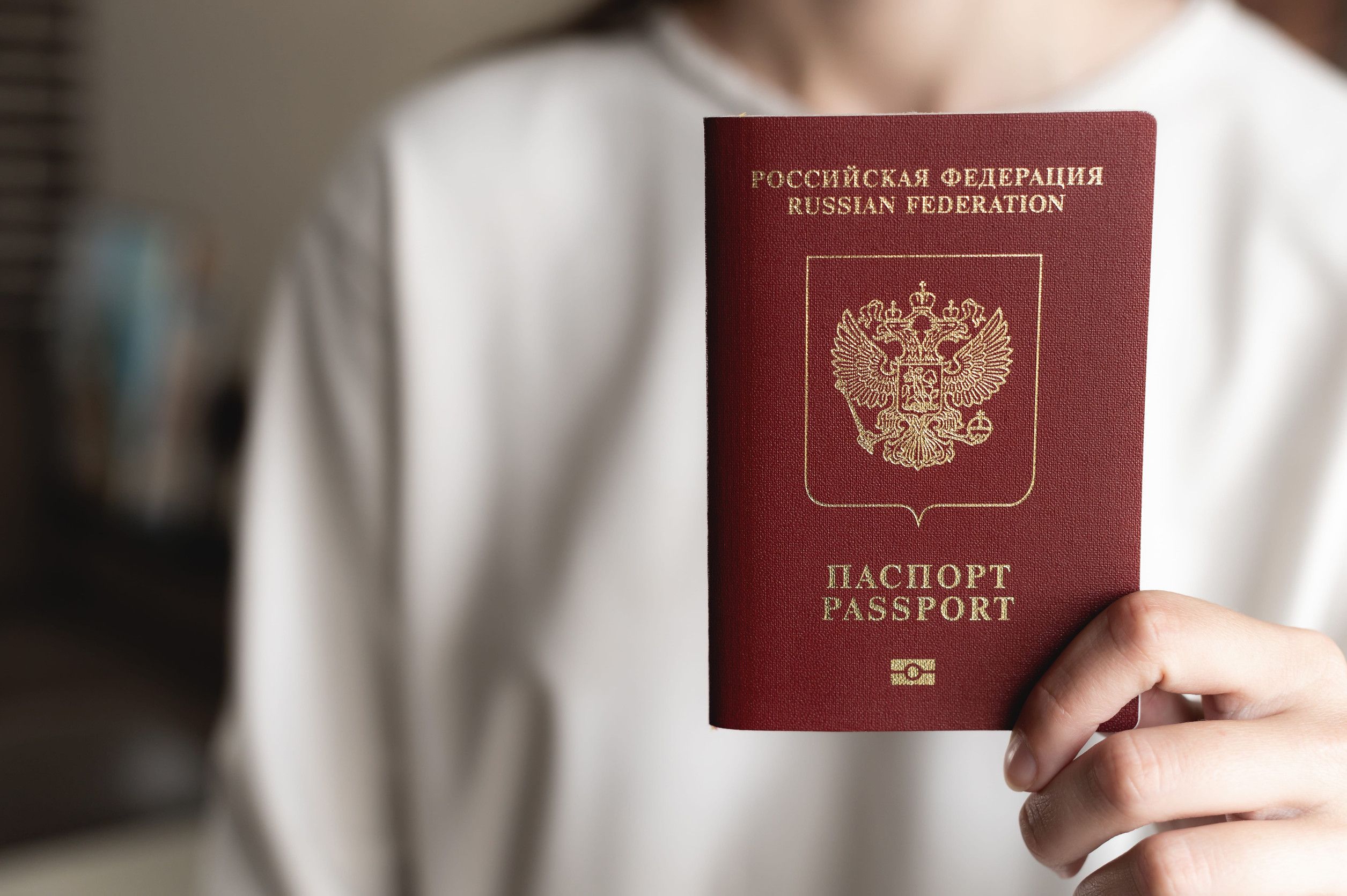 A Woman holding up a Russian passport
