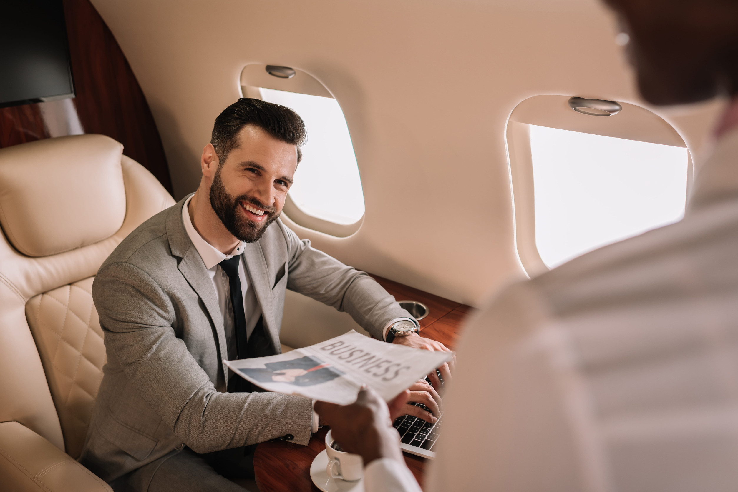 Businessman Receiving Newspaper From Stewardess