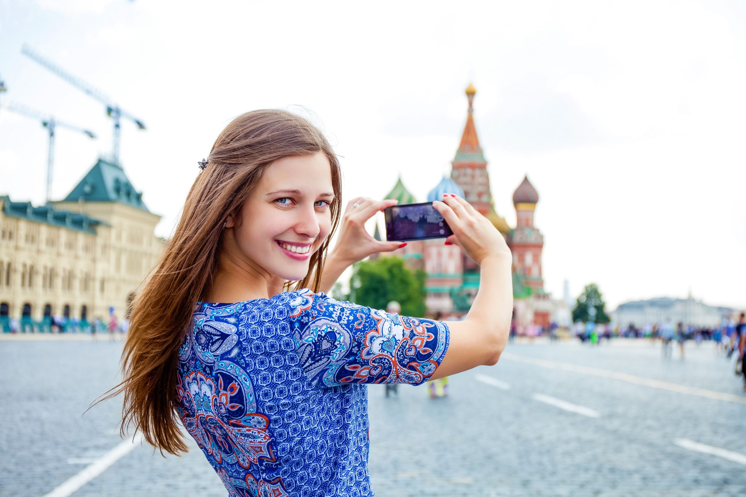 Happy young brunette woman photographed at attractions in Moscow