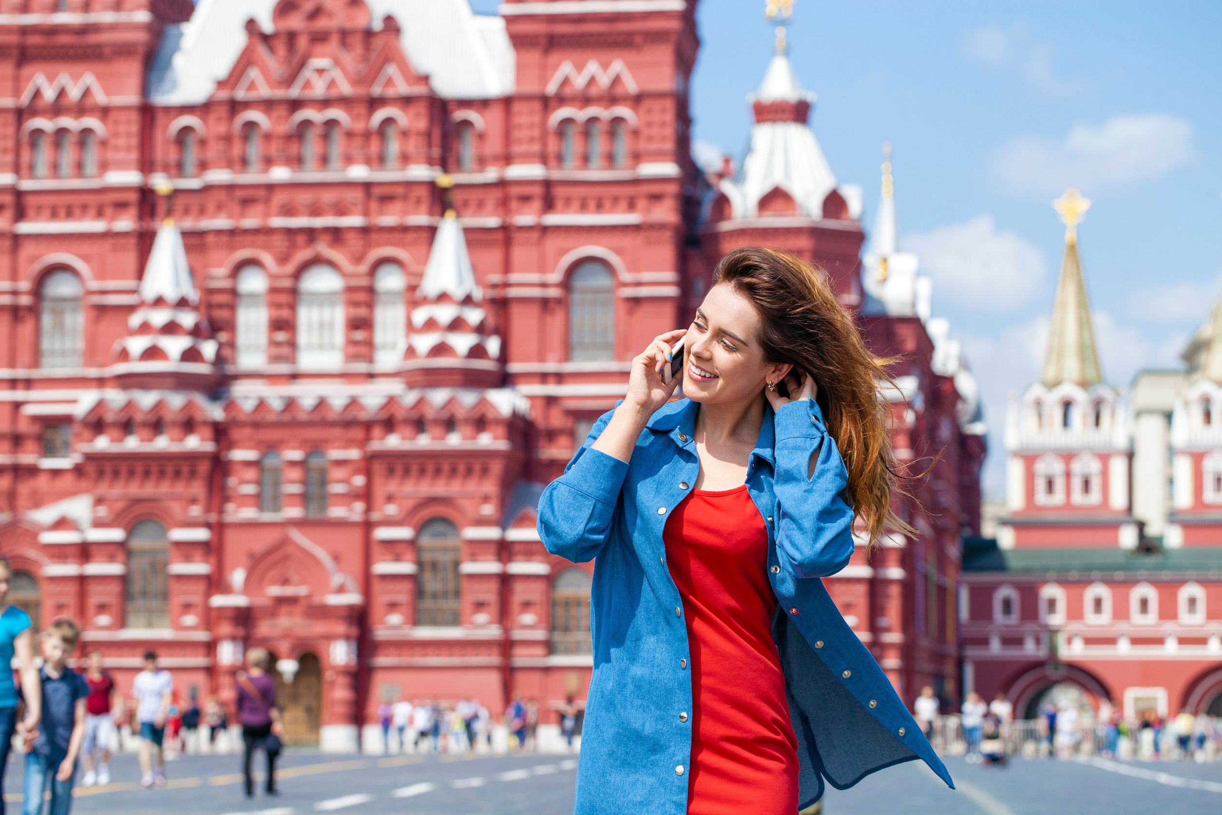 Happy young woman calling by phone in red square Moscow Russia