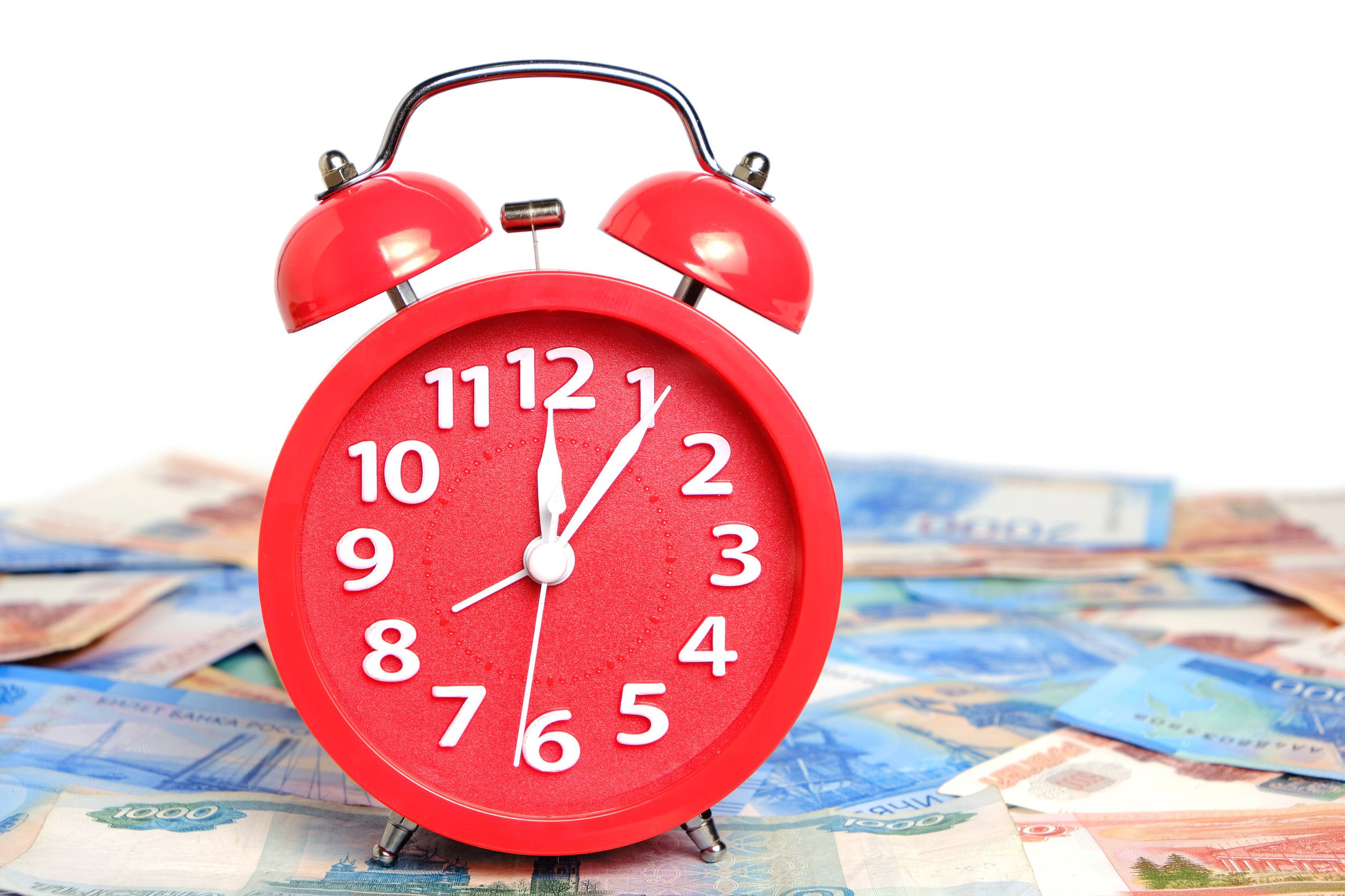 Russian rubles and red alarm clock on white background Russian rubles and red alarm clock on white background