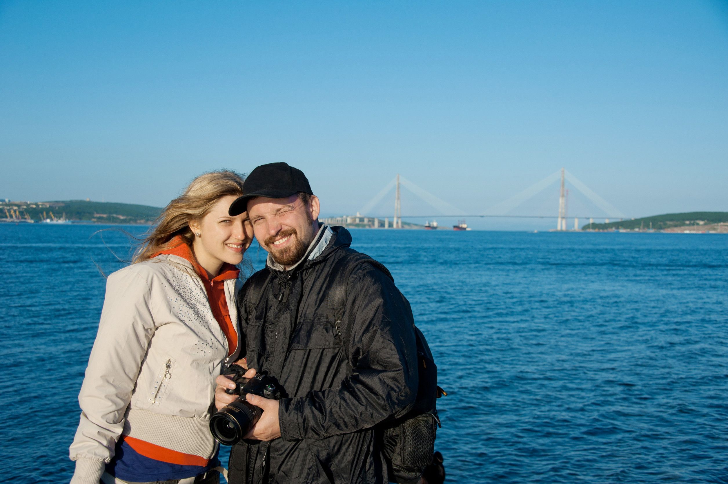 Young man with his girlfriend against the background of the bridge Young man with his girlfriend against the background of the bridge